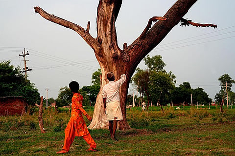 Budaun Killings: Ramesh Lal (name changed) walks past the tree, where dead bodies of his 14-year-old daughter and 11-year-old niece were found hanging 
